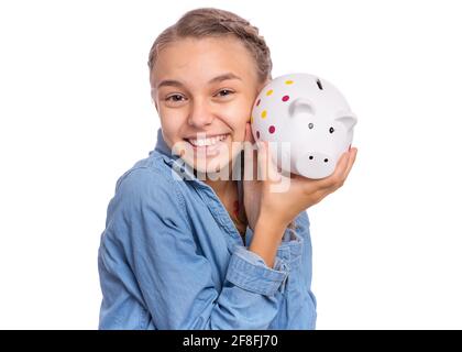 Belle adolescente tient une banque de porc dans ses mains, isolée sur fond blanc Banque D'Images