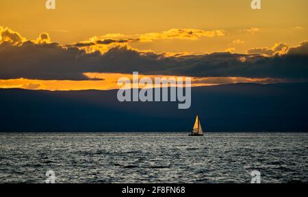 Yacht solitaire sur le lac Léman au coucher du soleil en Suisse Banque D'Images