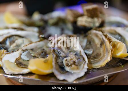 Huîtres fraîches avec citron. Huîtres fraîches. Gros plan d'un plat avec des coquillages. Banque D'Images