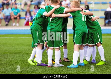 Les enfants ont une réunion dans une équipe sportive. Garçons jouant au sport d'équipe en extérieur. Des enfants heureux dans l'équipe et prêts à jouer le match de tournoi. UE Banque D'Images