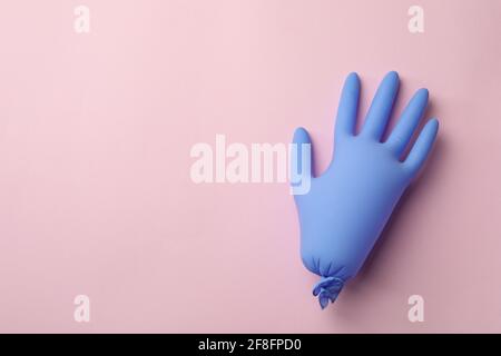 Gant médical gonflé sur fond rose, espace pour le texte Banque D'Images