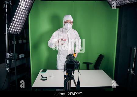 Un médecin en masque de protection et en costume enregistre la vidéo pour blog Banque D'Images
