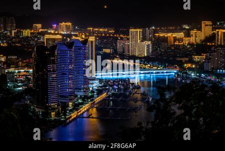 Panorama pittoresque de la ville de Sanya illuminé la nuit avec Sanya Pont fluvial et bâtiments modernes dans l'île de Sanya Hainan en Chine Banque D'Images