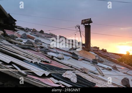 Erevan, Arménie, Alexander Kirillov - 30082019: Cond, toit en morceaux de tuiles, pierres et tuyaux rouillés Banque D'Images