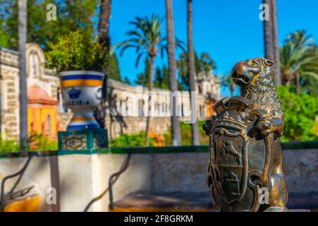 Lion aux armoiries dans les jardins du vrai Alcazar De Sevilla en Espagne Banque D'Images