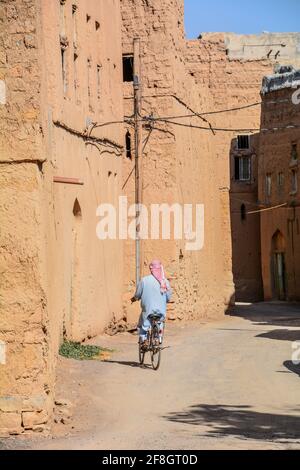 Cycliste solitaire dans un village d'Oman Banque D'Images