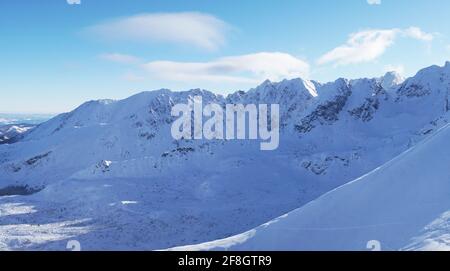 Vue pittoresque sur les montagnes enneigées avec un ciel bleu ciel pendant la saison d'hiver avec des sommets de montagne touchant le Ciel dans la ville de Zakopane - Kasprowy Wierch Banque D'Images