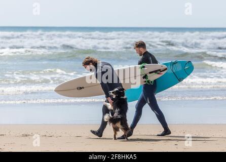 Garrettstown, Cork, Irlande. 14 avril 2021. Les surfeurs se dirigent vers la mer avec leur chien excitée à Garrettstown, Co. Cork, Irlande.- Credit; David Creedon / Alay Live News Banque D'Images