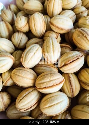 Cliché vertical de biscuits délicieux sous forme de noix avec condensé lait Banque D'Images