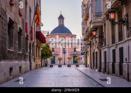 Vue au lever du soleil sur la basilique de la Virgen de los Desamparados à travers une rue étroite à Valence, Espagne Banque D'Images