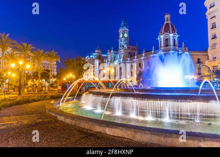 Vue nocturne de l'hôtel de ville derrière une fontaine en espagnol Ville de Valence Banque D'Images