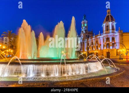 Vue nocturne de l'hôtel de ville derrière une fontaine en espagnol Ville de Valence Banque D'Images