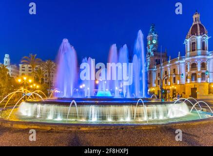 Vue nocturne de l'hôtel de ville derrière une fontaine en espagnol Ville de Valence Banque D'Images