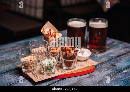 en-cas ou bière dans des verres sur une table en bois. Banque D'Images