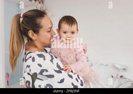 la jeune mère tient son enfant de 1 an. bien-être familial et psychologie de relation concept Banque D'Images