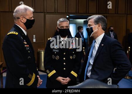 Christopher Wray, directeur du FBI, parle avec le général Paul Nakasone, directeur de la NSA, et le général Scott Berrier, directeur de l'agence de renseignement de la DIA, avant le début d'une audience de la commission du renseignement du Sénat sur les « menaces mondiales », à Capitol Hill, à Washington, le mercredi 14 avril, 2021. (Photo par Pool/Sipa USA Banque D'Images