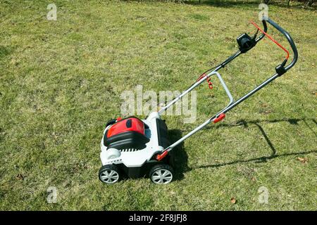 Aérateur dans l'herbe. Aération avec scarificateur. Utiliser un scarificateur dans le jardin pour améliorer la qualité de la pelouse au printemps. Banque D'Images