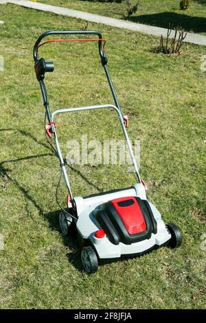 Aérateur dans l'herbe. Aération avec scarificateur. Utiliser un scarificateur dans le jardin pour améliorer la qualité de la pelouse au printemps. Banque D'Images