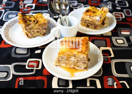 Trois assiettes de crêpes cuites farcies de caillé et de confiture sur fond coloré. Banque D'Images