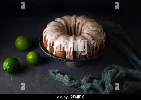 Gâteau au citron sur fond noir accompagné de citrons Banque D'Images