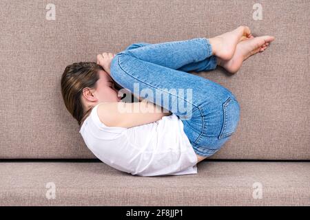 La jeune femme est en posture fœtale ou embryonnaire. Vue de dessus Banque D'Images