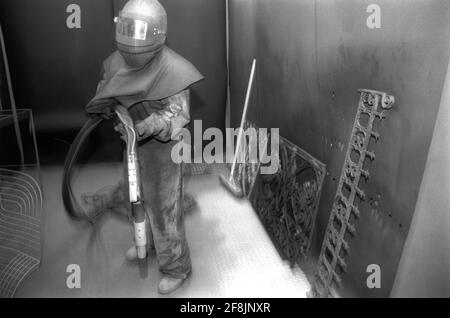 Nettoyeur haute pression sablage d'un radiateur dans un atelier clos Banque D'Images