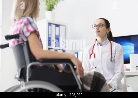 Femme handicapée en fauteuil roulant assise dans le bureau du médecin Banque D'Images