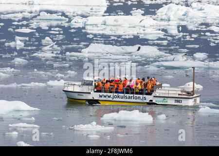 Touristes en excursion en bateau amphibie à Jökulsárlón / Joekusarlon en été, lac glaciaire dans la partie sud du parc national de Vatnajökull, sud-est de l'Islande Banque D'Images