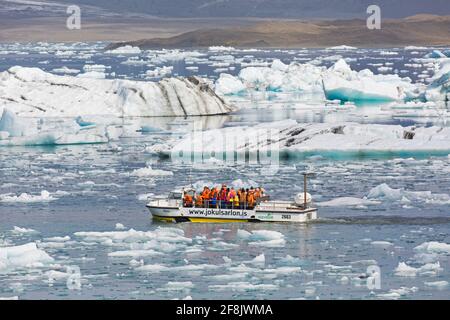 Touristes en excursion en bateau amphibie à Jökulsárlón / Joekusarlon en été, lac glaciaire dans la partie sud du parc national de Vatnajökull, sud-est de l'Islande Banque D'Images