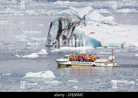 Touristes en excursion en bateau amphibie à Jökulsárlón / Joekusarlon en été, lac glaciaire dans la partie sud du parc national de Vatnajökull, sud-est de l'Islande Banque D'Images