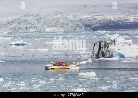 Touristes en excursion en bateau amphibie à Jökulsárlón / Joekusarlon en été, lac glaciaire dans la partie sud du parc national de Vatnajökull, sud-est de l'Islande Banque D'Images