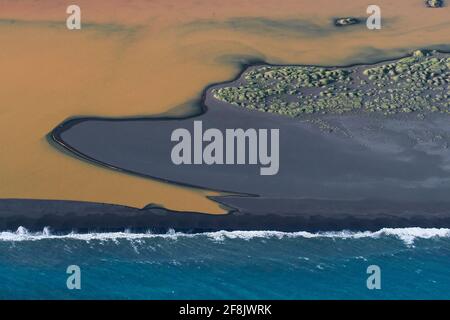 Vue aérienne sur Landeyjarsandur montrant la plage avec le sable volcanique noir et l'eau brune chargée de sédiments coulant dans la mer en été, Islande Banque D'Images