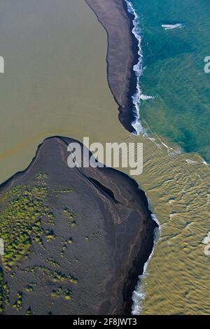 Vue aérienne sur Landeyjarsandur montrant la plage avec le sable volcanique noir et l'eau brune chargée de sédiments coulant dans la mer en été, Islande Banque D'Images