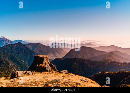 Vue sur la chaîne de montagnes de l'Himalaya avec silhouettes visibles à travers le brouillard coloré du sentier de randonnée de Khalia. Le sommet de Khalia est à une altitude de 3500m h. Banque D'Images