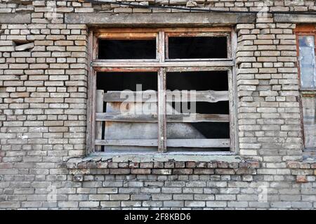 Devant le bâtiment abandonné. Mur avec fenêtre. Ruine, dévastation, effondrement, crise, guerre. Banque D'Images