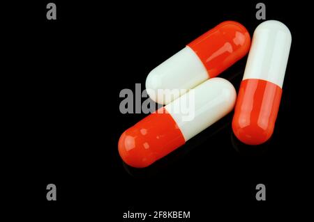 Pilules. Fournitures médicales.trois capsules isolées sur fond noir. Banque D'Images