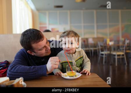 La famille qui boit du jus dans un restaurant Banque D'Images