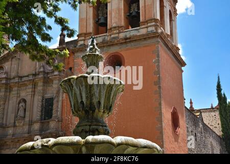 Vue sur le style baroque Templo de San Francisco avec une fontaine en pierre au premier plan dans le centre historique de San Luis Potosí, Mexique. Banque D'Images