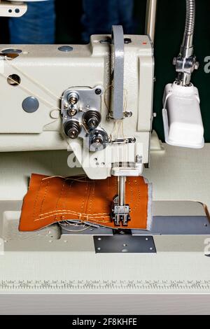 Le mécanisme de travail d'une machine à coudre industrielle pour la fabrication de meubles rembourrés en imitations de cuir et autres tissus denses. Banque D'Images