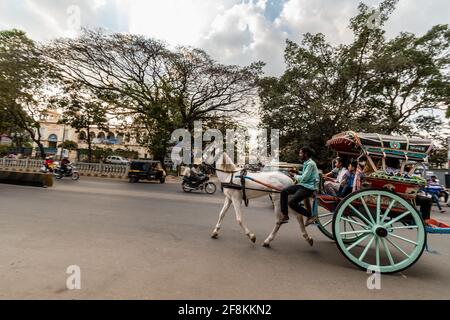 Mysuru, Karnataka, Inde - janvier 2019 : une voiturette à cheval avec des passagers traversant les rues de la ville de Mysore. Banque D'Images