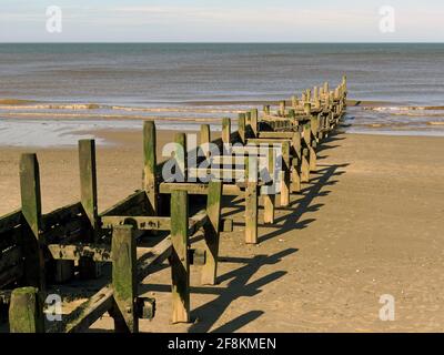 Défenses marines protégeant la plage et les falaises du populaire village résidentiel et de vacances d'Overstrand sur la côte nord de Norfolk. Banque D'Images