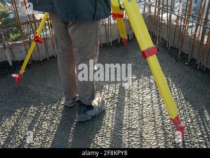 le spécialiste de la géodésie travaille sur un chantier de construction. trépied et équipement spécial pour la géodésie. Photo de haute qualité Banque D'Images