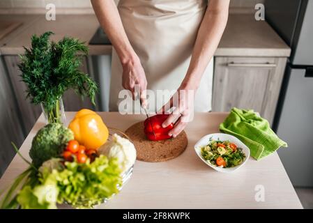 les hommes hacher la salade et l'oignon, cuisiner des aliments sains dans la cuisine. Banque D'Images