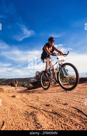 Une concurrente féminine dans une course de VTT près de Moab, Utah. Banque D'Images