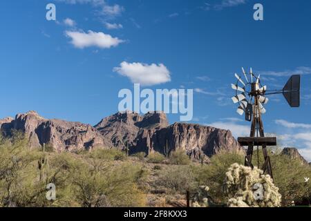 Un ancien moulin à vent en bois avec la montagne de Superstition en arrière-plan au musée de montagne de Superstition en Arizona. Banque D'Images