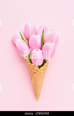 Bouquet de tulipes roses en gaufre de glace sur fond rose. Fête des mères, Saint Valentin, Bachelorette, concept d'été. Espace de copie, vue de dessus. Mi Banque D'Images