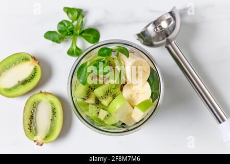 différents morceaux de fruits dans le mélangeur containeron table de cuisine, vue de dessus sélective foyer Banque D'Images