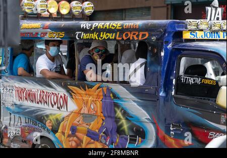 Passagers à l'intérieur d'un véhicule utilitaire multilab coloré portant un masque facial, Cebu City, Philippines Banque D'Images