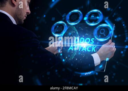 Concept commercial, technologique, Internet et réseau. Jeune homme d'affaires travaillant sur un écran virtuel du futur et voit l'inscription: Attaque DDoS Banque D'Images