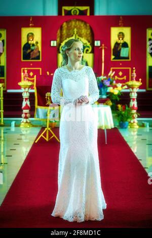 Femme en robe de mariage blanche et une coiffure étonnante sur la cérémonie de mariage orthodoxe russe à l'église orthodoxe russe aux États-Unis. Banque D'Images